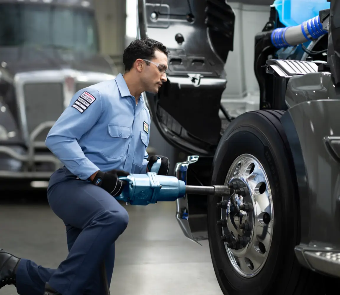 A Kenworth technician services a truck